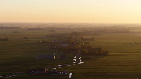 Early-misty-morning-in-small-rural-town,-majestic-sunrise,-aerial-drone-view