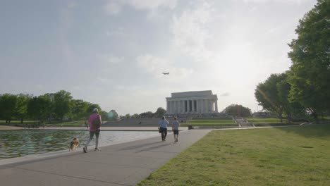 Pedestrians-walk-by-the-reflecting-pool-with-the-Lincoln-Memorial-in-the-background