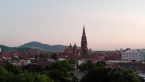 Freiburg-Im-Breisgau-Stadtansicht-Kirche-Schwarzwald-Deutschland-4K-Filmische-Luftaufnahme