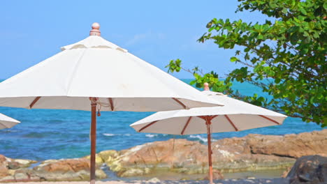 White-Beach-Parasols-and-Blue-Tropical-Sea-on-Summer-Breeze,-Detail
