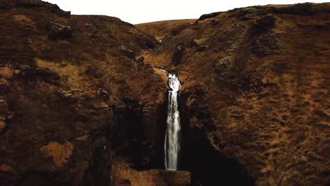 Luftaufnahme-Des-Wassers,-Das-Im-Winter-Einen-Wasserfall-In-Island-Hinunterfließt
