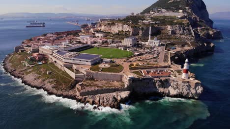 Luftaufnahme-Des-Europa-Point-In-Gibraltar-Mit-Wellen,-Die-Auf-Felsen-Krachen