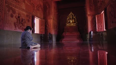 Asiatische-Frau-Betet-Im-Buddhistischen-Tempel,-Der-Auf-Dem-Boden-Sitzt