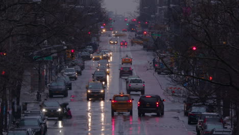 Slow-mo-of-a-wet-New-York-Manhattan-main-street-with-traffic,-in-winter-with-snow
