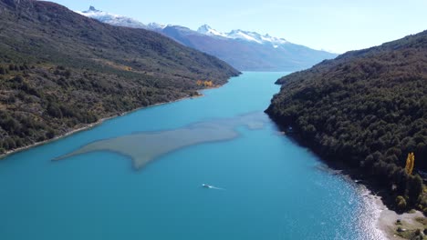 Top-aerial-drone-panoramic-view-Beautiful-snowy-mountains-landscape-and-a-impressive-turquoise-cristal-clear-river-along-gravel-road-Carretera-Austral-in-southern-Patagonia,-Chile