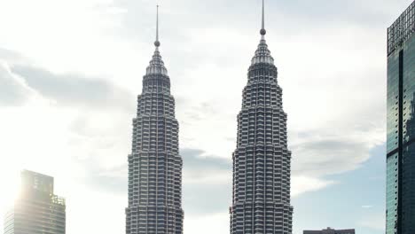Toma-Aérea-Macro-única-De-La-Torre-Petronas-De-Kuala-Lumpur-Mientras-El-Sol-Brilla-Detrás-Del-Edificio-Durante-La-Puesta-De-Sol-En-Malasia