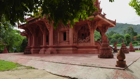 Roter-Buddhistischer-Tempel,-Umgeben-Von-Grünen-Bäumen-In-Thailand