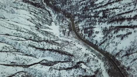 Flying-over-country-road-in-snowy-valley