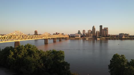 Louisville,-Kentucky-skyline-with-bridge-and-trees-with-drone-video-moving-down