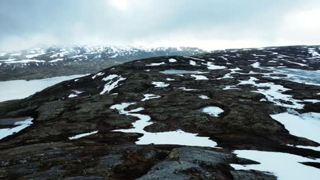 Luftflug-über-Felsige,-Verschneite-Landschaften-Mit-Dem-Middalen-Gletscher-Im-Hintergrund-In-Norwegen
