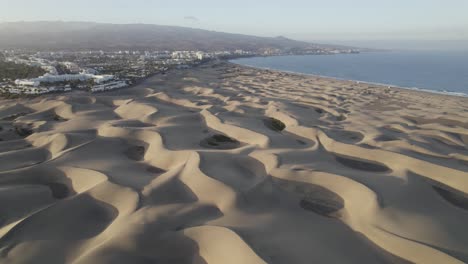 Wellenmuster-Auf-Sanddünen-Von-Maspalomas-Und-Ruhigem-Meerwasser,-Gran-Canaria,-Spanien