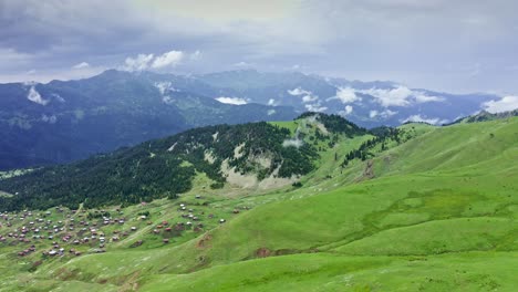 Aerial-View-From-Drone-Of-Green-Mountain-Plateau-With-Small-Village-On-The-Slope