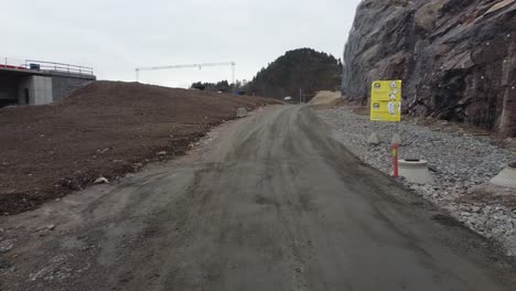 Construction-road-with-warning-signs-at-Klepland-between-Mandal-and-Kristiansand---Construction-of-new-highway-E39-by-companye-Nye-Veier-AS