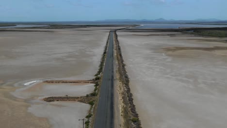 Rectilinear-deserted-road-across-wild-flat-territory-of-Casuarina-island-in-Queensland,-Australia