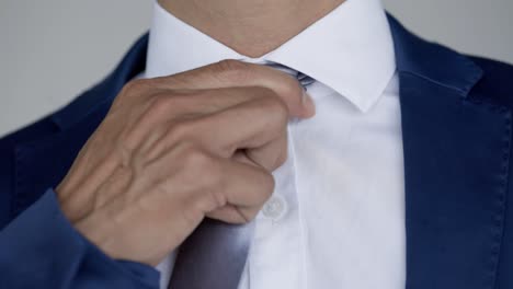Kaukasischer-Mann-Mit-Blauem-Blazer-Und-Weißem-Hemd-Passt-Silberne-Krawatte-An