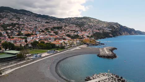 Luftaufnahme-Der-Stadtlandschaft-Und-Touristen,-Die-Am-Strand-In-Funchal,-Madeira,-Portugal-Liegen