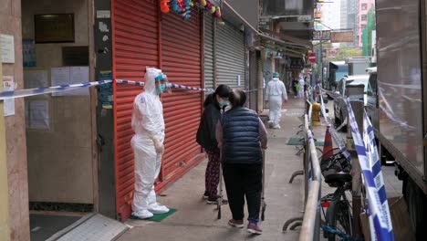 Bewohner-Gehen-In-Einem-Abgesperrten-Bereich-Durch-Das-Viertel,-Um-Die-Ausbreitung-Des-Ausbruchs-Der-Coronavirus-Variante-In-Hongkong-Einzudämmen