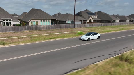 White-Tesla-Model-3-electric-car-drives-on-road-in-Texas