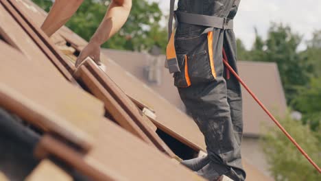 Roofing-scene-of-worker-on-rooftop-removing-tiles