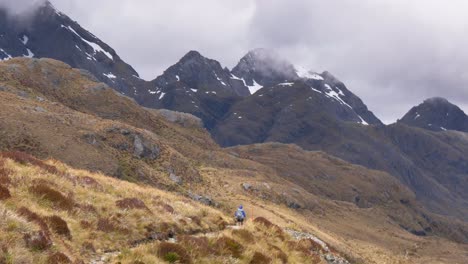 Static,-solo-female-hiker-crosses-exposed-alpine-pass,-Routeburn-Track-New-Zealand