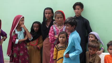 Numerosos-Niños-De-Pie-En-La-Línea-En-El-Campamento-De-Socorro-De-Inundaciones-Para-Recibir-La-Ayuda-En-Sindh,-Pakistán