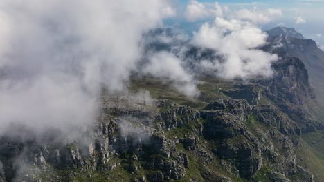 Cloudscape-rolling-above-majestic-mountain-range-in-South-Africa,-aerial-view