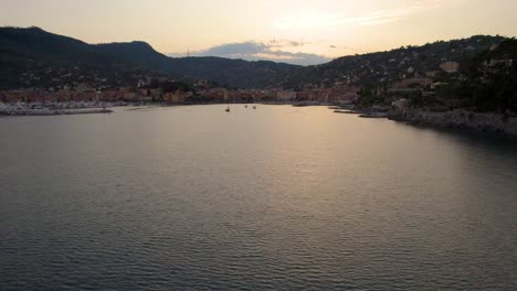 Gorgeous-Sunset-Reflecting-on-Ocean-Surface-on-Coast-of-Portofino,-Italy---Aerial-Establishing-Flight-with-Copy-Space-in-Sky