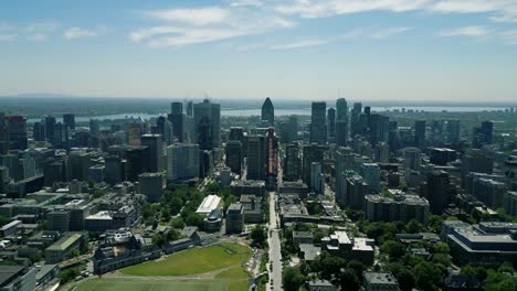 4K-Cinematic-urban-drone-footage-of-an-aerial-view-of-buildings-and-skyscrapers-in-the-middle-of-downtown-Montreal,-Quebec-on-a-sunny-day