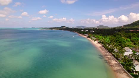 4k-Drone-Footage-of-the-Beach-at-Mae-Nam-on-Koh-Samui-in-Thailand,-Including-Beachfront-Resorts-with-Beautiful-Clouds-in-the-Sky-and-Crystal-Teal-Water