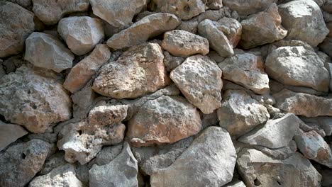 Down-dolly-slide,-Wall-of-large-uncut-stones-with-visible-cement-between-the-stones