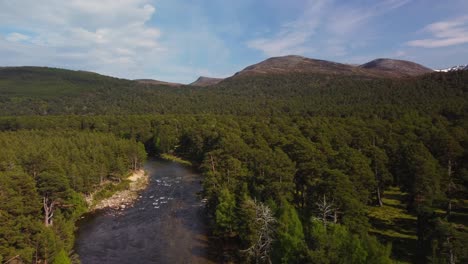 Scotland-Countryside-Drone-Shot-of-River-and-Mountain-in-Distance