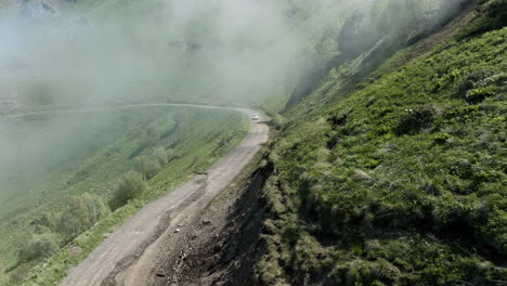 Car-Driving-On-Dirt-Road-Of-Tskhratskaro-Pass-Passing-Through-Fog-On-A-Sunny-Day-In-Georgia