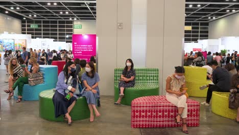 Art-buyers-and-visitors-are-seen-sitting-on-colorful-benches-at-a-rest-area-during-a-contemporary-art-fair-open-to-the-public