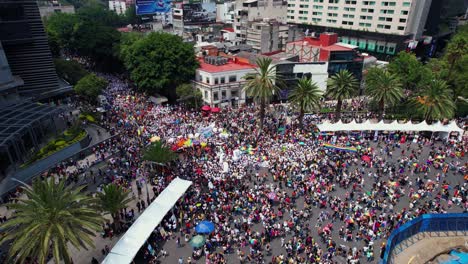 Aerial-View-of-Crowd-of-multi-ethnic-people-taking-a-stand-for-Gay-Pride-In-Mexico-City---reverse,-tilt,-drone-shot