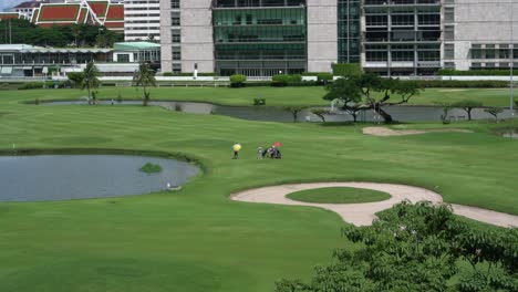 People-playing-golf-at-The-Royal-Bangkok-Sports-Club-golf-course-in-Pathumwan,-central-Bangkok,-Thailand
