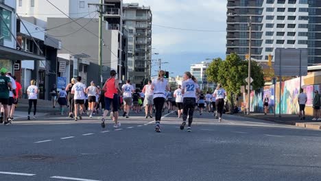 Group-of-generous-participants-running-for-Bridge-to-Brisbane-fundraise-event-to-raise-funds-for-charity,-showing-love-and-support-for-good-cause,-handheld-motion-shot-on-Brookes-st,-Bowen-Hills