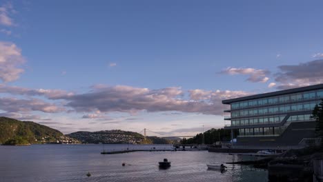 El-Puente-Askoy-En-Bergen,-Noruega-En-La-Distancia-Mientras-Los-Barcos-Se-Mueven-En-El-Agua-Y-Las-Nubes-Cruzan-El-Cielo