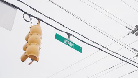 Camera-Orbit-around-Main-Street-Sign-with-powerlines-in-Downtown-Davidson,-North-Carolina-during-December
