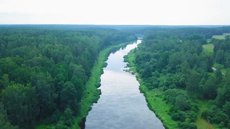 Aerial-view-of-a-Venta-river-on-a-sunny-summer-day,-lush-green-trees-and-meadows,-beautiful-rural-landscape,-high-altitude-wide-angle-drone-shot-moving-forward