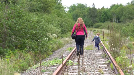 Una-Madre-Caminando-Con-Su-Hijo-En-Un-Ferrocarril-Abandonado