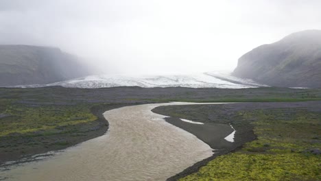 Glacier-in-Iceland-with-water-with-drone-video-moving-forward-with-a-low-view