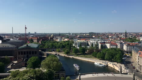 Berlin-Skyline-with-a-view-of-the-Spree-River,-boats,-trains,-and-people-walking