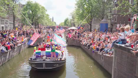Boat-with-US-flags-celebrating-Pride-day-during-parade-in-Amsterdam,-Netherlands