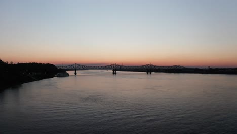 Wide-rising-aerial-shot-of-the-Natchez-Vidalia-bridge-on-the-Mississippi-River-at-sunset