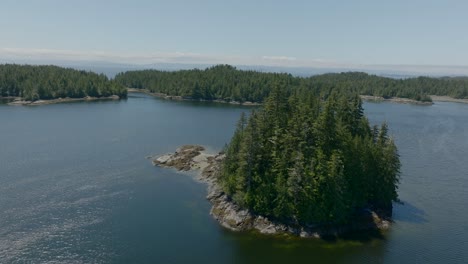 Drone-footage-circling-a-small-island-in-a-bay-on-the-pacific-ocean-near-Vancouver-Island,-British-Columbia-Canada