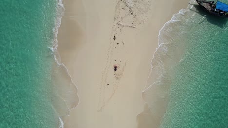Alone-in-a-sandbank-with-a-wooden-boat-in-Zanzibar,-Tanzania