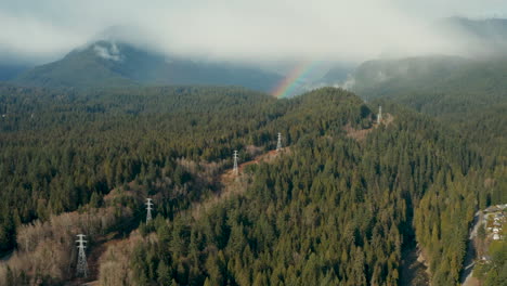 Vuelo-Aéreo-Hacia-Un-Arco-Iris-En-El-Impresionante-Bosque-De-Montaña-Alrededor-Del-Norte-De-Vancouver,-Columbia-Británica