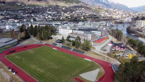 Sportarena-Und-Voss-Gymnas-Schulgebäude-Mit-Vorbeifahrendem-Vy-Zug-Im-Hintergrund-–-Norwegen