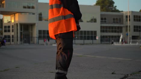 Security-Officer-Holding-Two-way-Radio-And-Wearing-Bright-High-visibility-Vest-Standing-In-The-Street