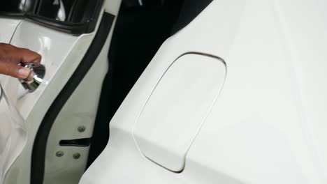 Close-up-mans-hand-opening-back-white-car-door